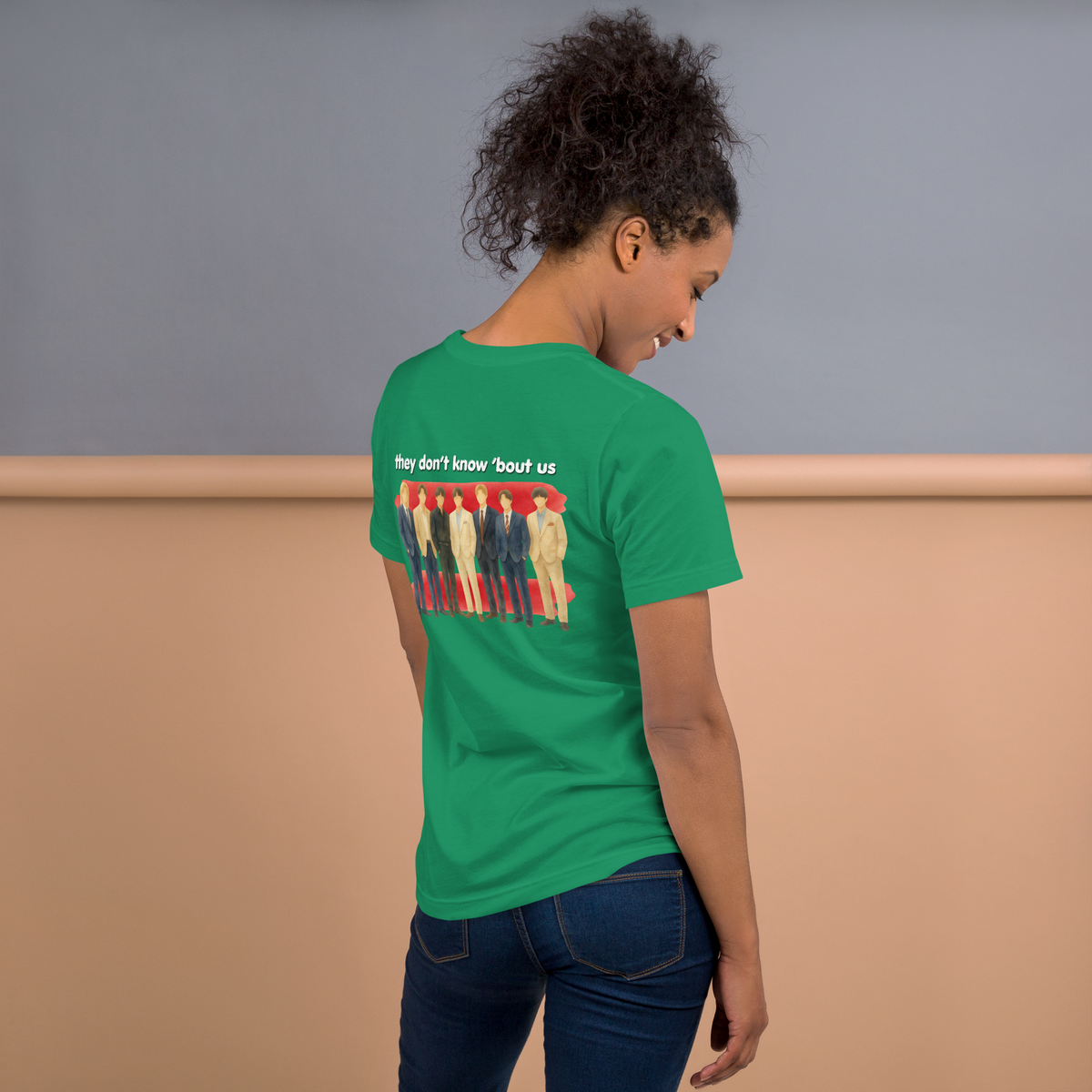 Person wearing a green t-shirt with a colorful graphic and text on the back, standing against a plain background. - Laureles Internacionales Unisex T-Shirt | Serendipitous Landing