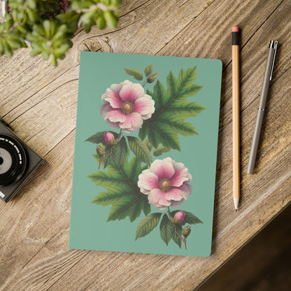 Notebook with floral design on a wooden surface with a pencil and pen. - mugunghwa and oak leaf botanical design - teal / sage green cover, perforated notebook