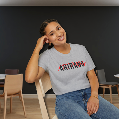 Woman wearing a gray t-shirt with 'ARIRANG' printed on it, sitting in a room with chairs and tables. - Bangtan 2026 Unofficial Shirt [Bias Arirang Color Vinyl Edition], OT7 - silver, RM, Kim Namjoon, Rap Monster