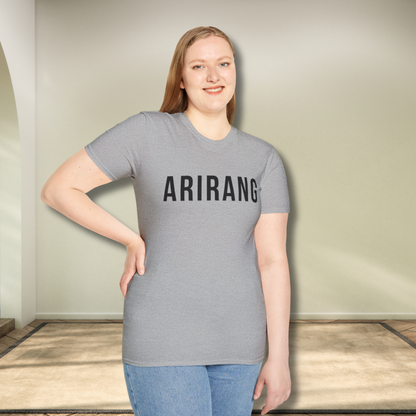 Person wearing a gray t-shirt with 'ARIRANG' printed on it, standing indoors. - Bangtan Tour 2026 Unofficial Shirt [Bias Arirang Color Vinyl Edition, Simple Text]