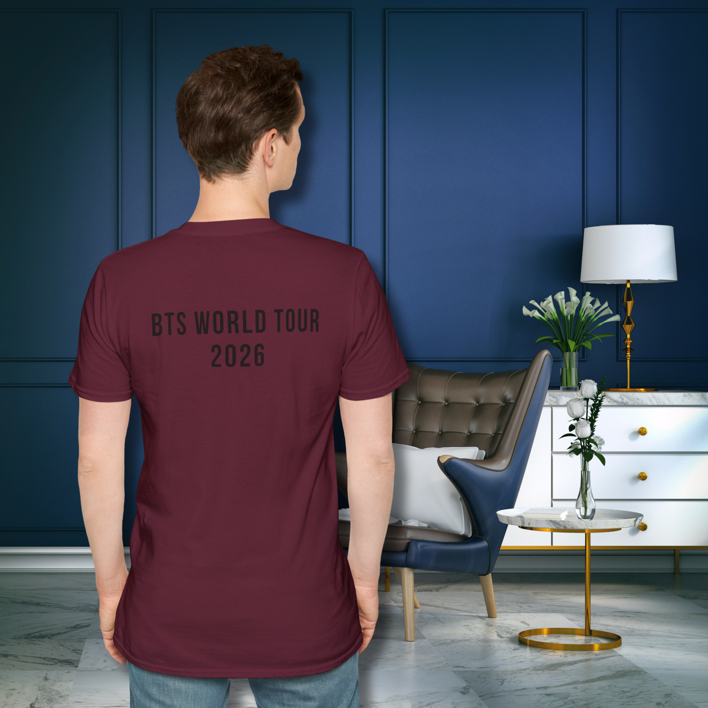 Person wearing a maroon t-shirt with 'BTS World Tour 2026' text in a modern living room. - Jimin Burgundy