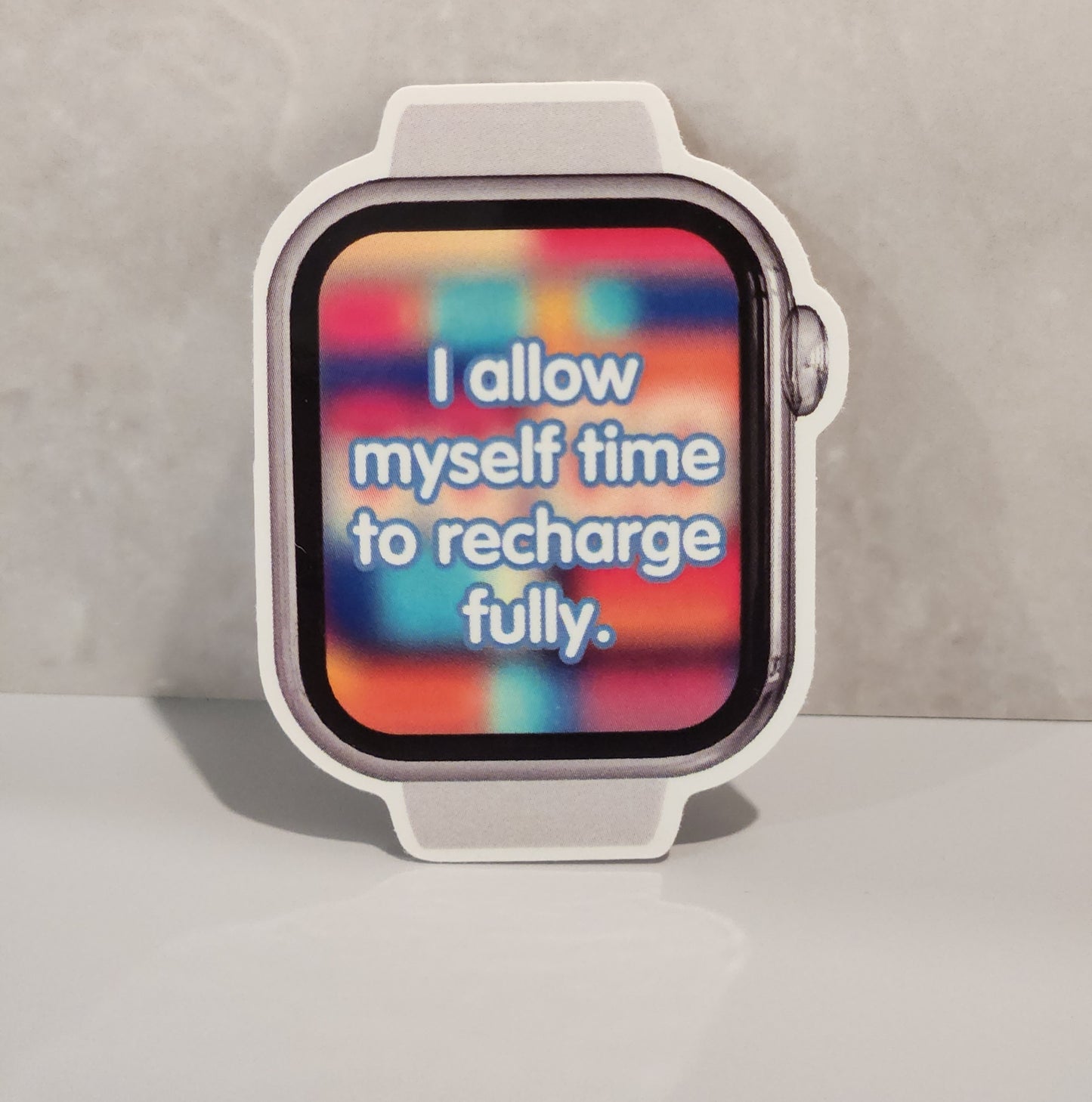 Smartwatch with a colorful display on a gray background- affirmation stickers - friends, zero oclock, yet to come, answer: love yourself, magic shop