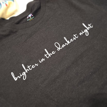 Black t-shirt with white text 'brighter in the darkest night' on a plain background --  The Insignia Bloom Long Sleeve Shirt (Unisex) - 7 Stars collection design - BTS / Bangtan members birth flowers and Arirang vinyl colors