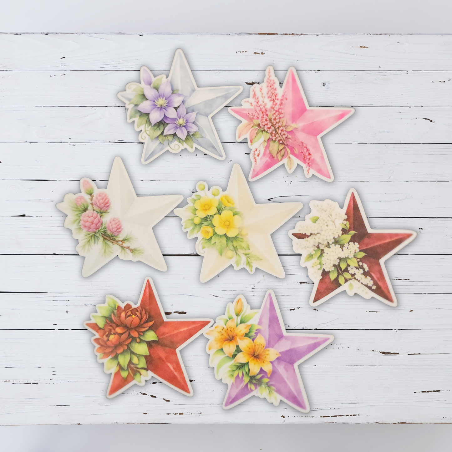 Star-shaped decorative items with floral designs on a wooden surface - Seven Arirang colored star stickers with BTS members birth flowers, bangtan sonyeondan
