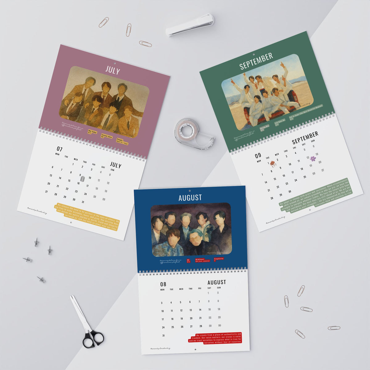 Three calendars for July, August, and September on a light gray background with office supplies. - BTS 2026 Wall Calendar - Bangtan Affirmations, OT7 Watercolor Art | Monthly Song Recommendations