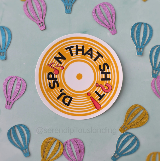 Circular sign with text surrounded by colorful hot air balloon cutouts on a light blue background - DJ Spin That Sticker | Serendipitous Landing