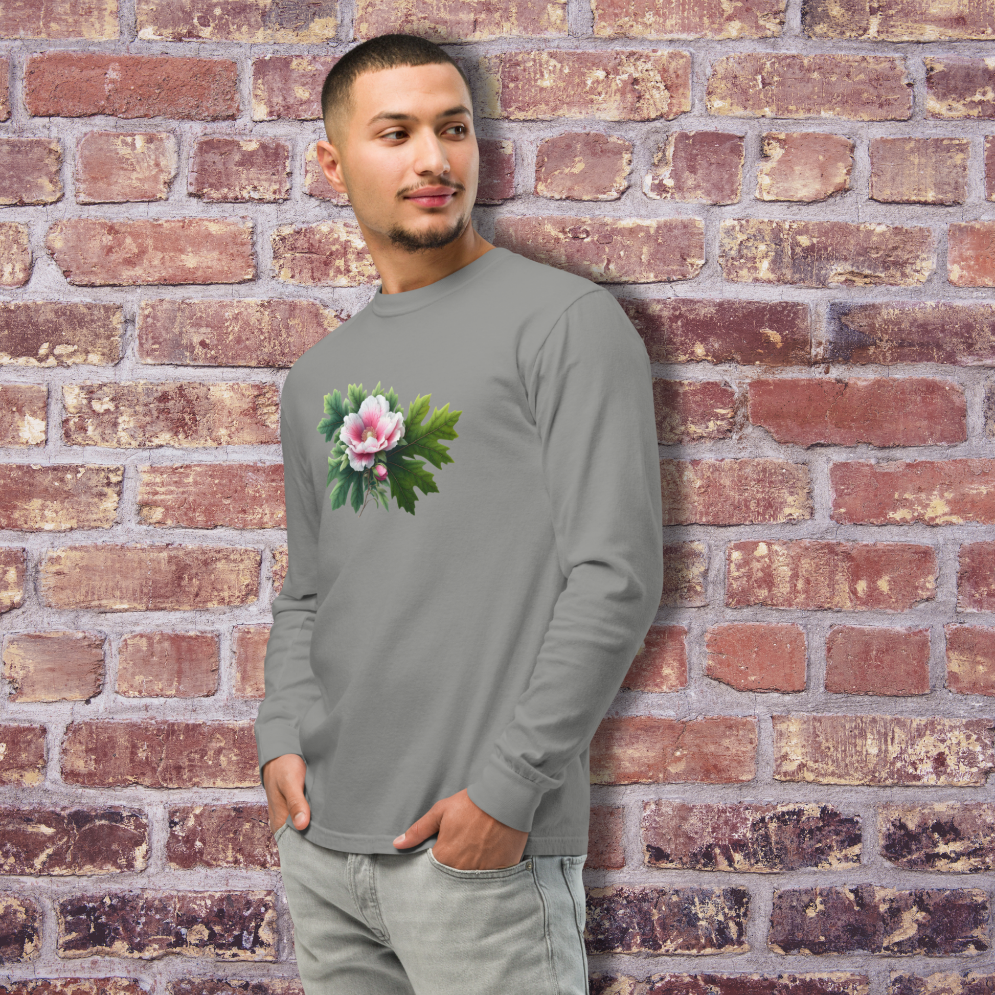 Man wearing a gray long-sleeve shirt with a floral design against a brick wall. - mugunghwa and oak leaf botanical design - medium grey gray long sleeve tee, tshirt