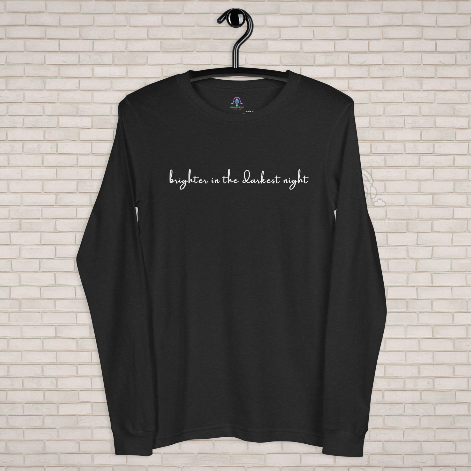 Black long-sleeve shirt with 'brighter in the darkest night' text on a white brick wall background - The Insignia Bloom Long Sleeve Shirt (Unisex) - 7 Stars collection design - BTS / Bangtan members birth flowers and Arirang vinyl colors