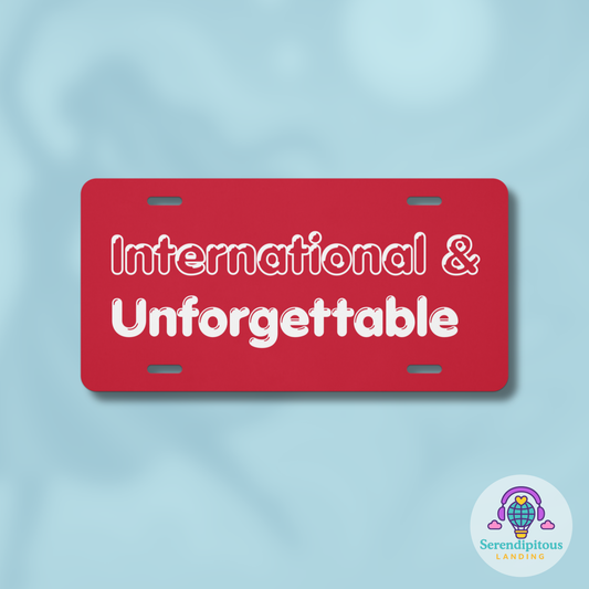 Red license plate with 'International & Unforgettable' text on a light blue background, featuring the Serendipitous Landing logo. - Laureles Internacionales Vanity License Plate