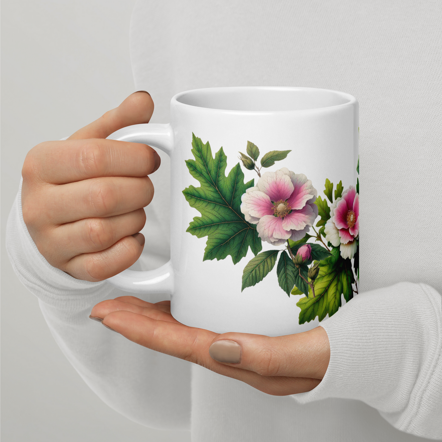 Hand holding a white mug with floral design on a light gray background - mugunghwa and oak leaf botanical design - 20 oz ceramic mug